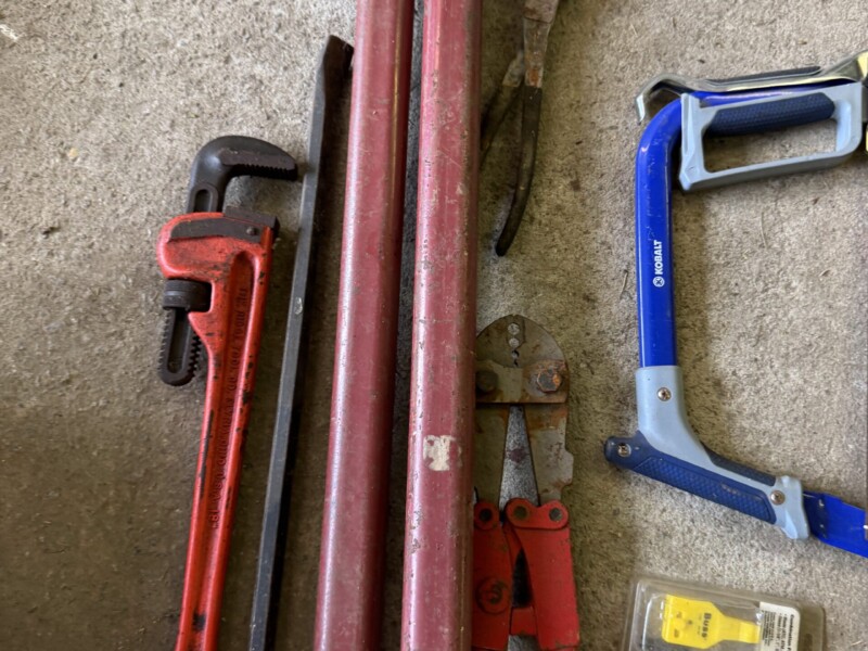 Lot 33: T post puller, crimper tool, saw, bucket buddy, pipe wrench.