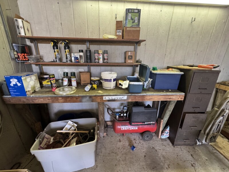 Lot 49: Bench contents, file cabinet, air compressor. Would not come on. Spray paint cans